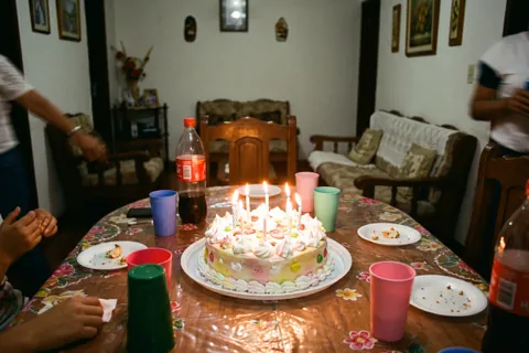 Torta de cumpleaños con velas en una sala familiar